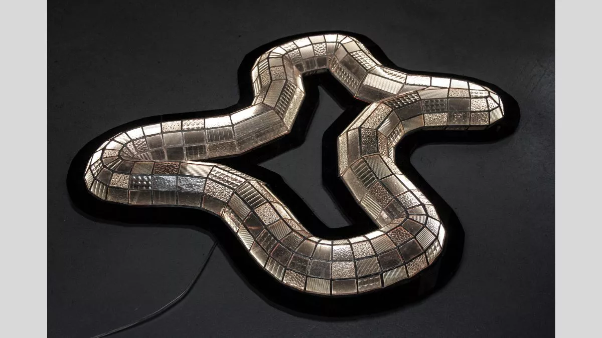 An abstract shape with 4 corners made with reflective gold tiles of different textures