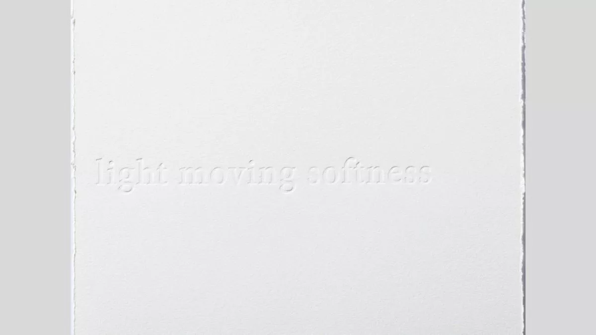 A white canvas with frayed edges and embossed the words 'light moving softness'