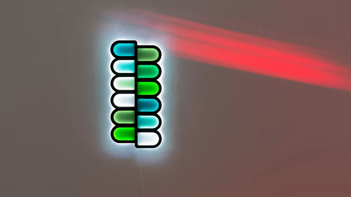 Artwork featuring a vertical line of half-oval shapes in green, blue and white, pushed against each other.