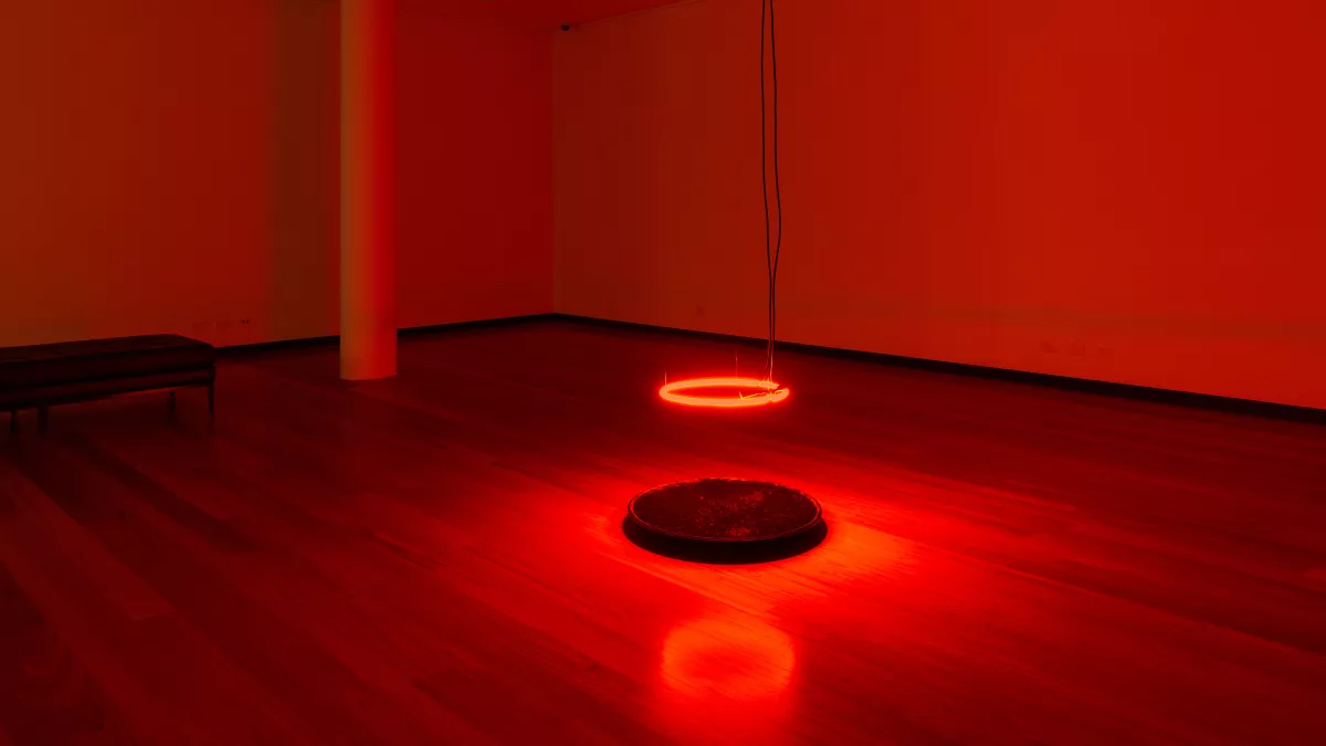 Art installation featuring a red illuminated circle hanging from the roof.