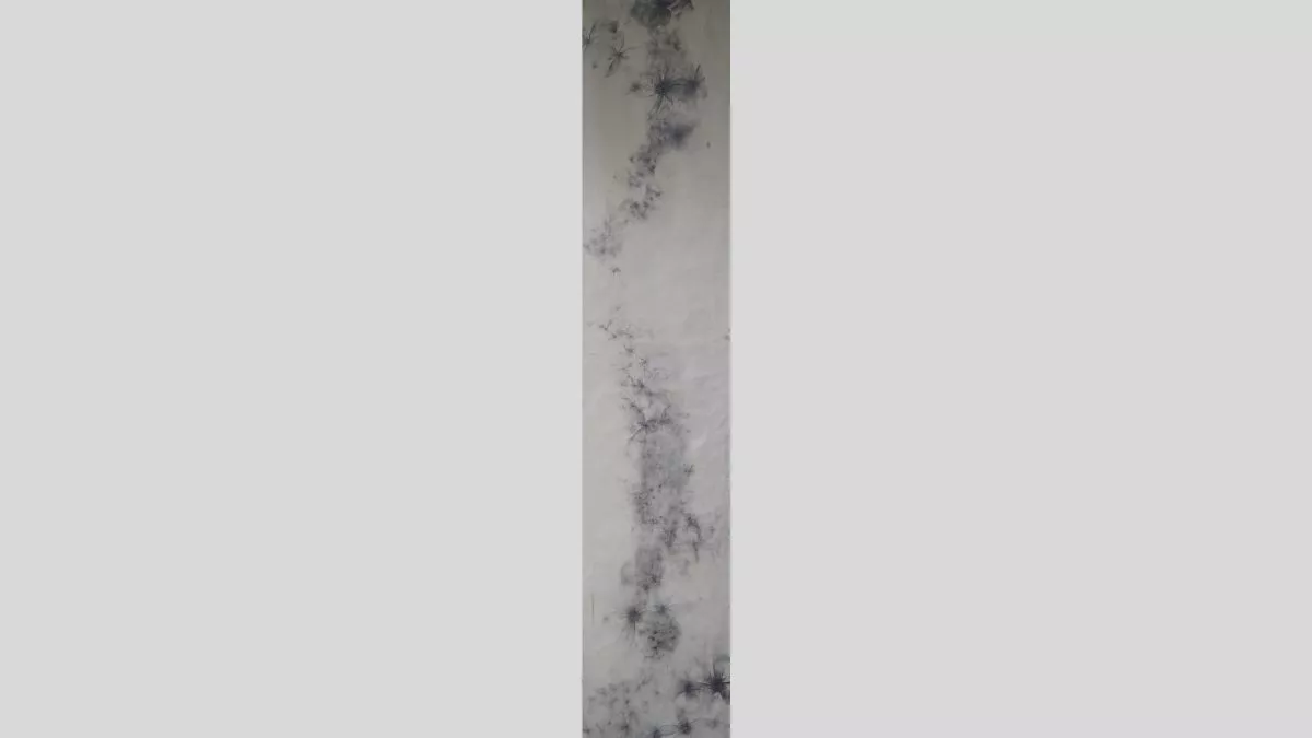 An artwork in a single vertical strip, showing dark buise-like patterns of marks and lines across a pale surface