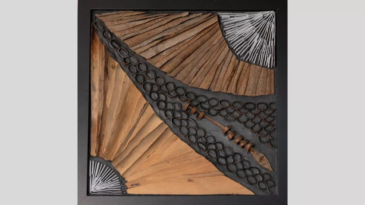 An artwork using strips of bark to divide the square canvas in two, with a gap inbetween where rings interlock around a small spear-like shape