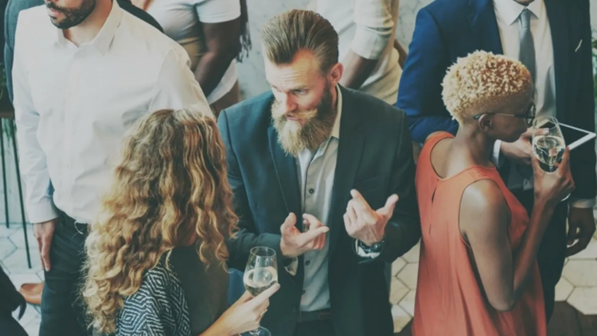 A busy room filled with people talking to each other
