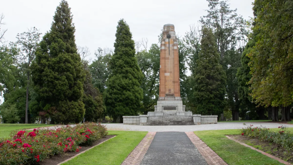 a cenotaph surrounded by neat lawns and cypress trees