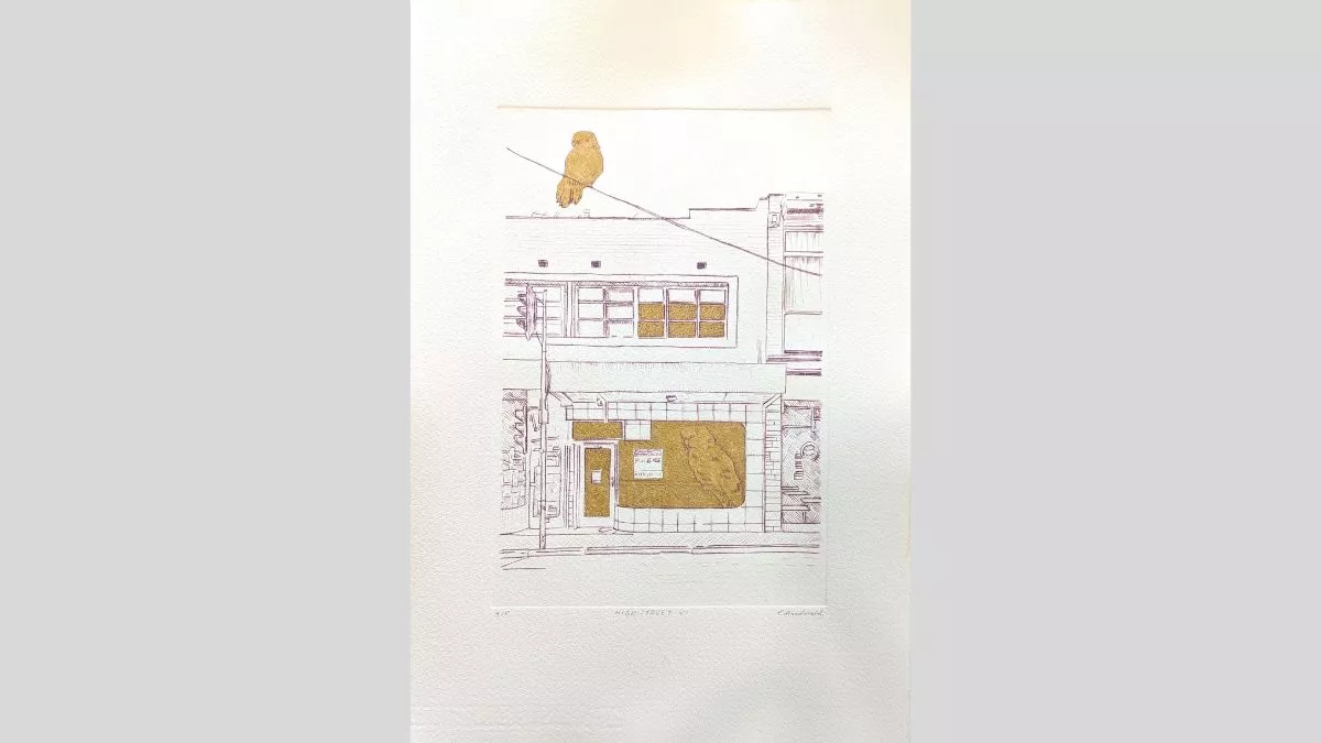 An etching of a shopfront with a bird in the window and on top of the building. Features sections of gold leaf.