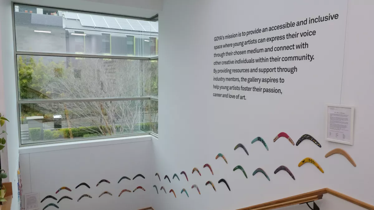Staircase with colourful boomerangs along wall.