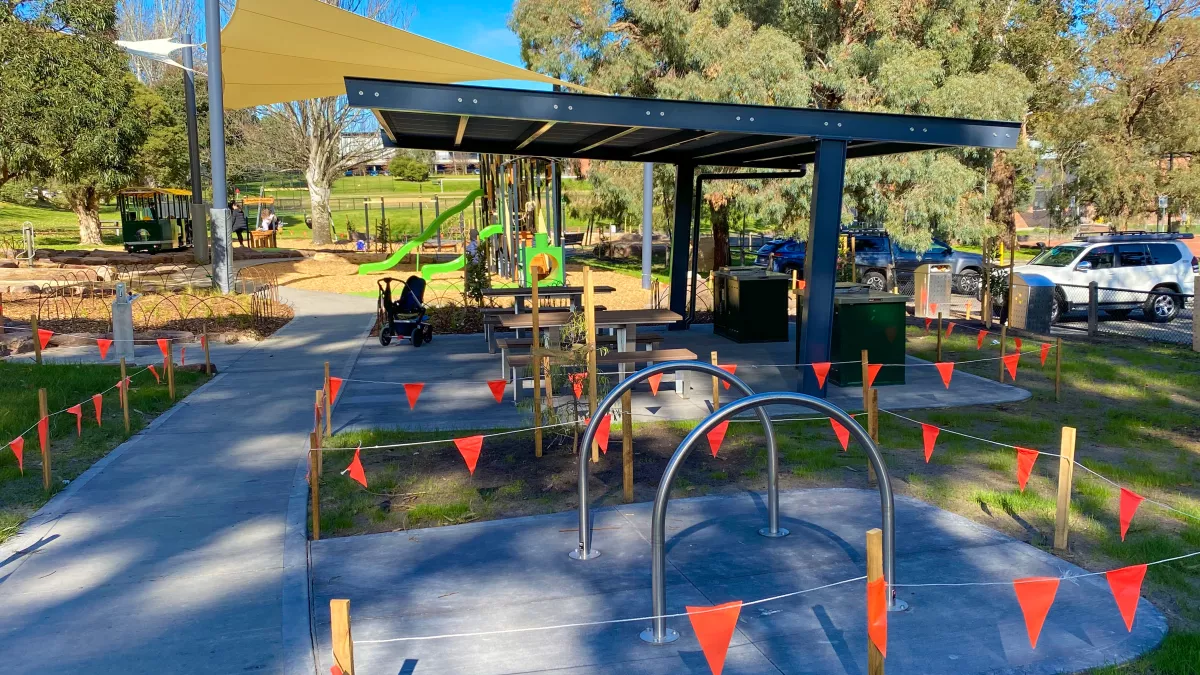 Bike parking hoops and a picnic shelter at a park