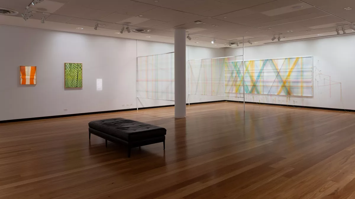 Photo of mixed media artwork and paintings in a gallery. 
