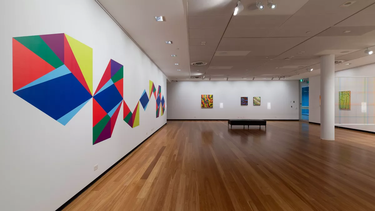 Photo of mixed media artwork and paintings in a gallery. 