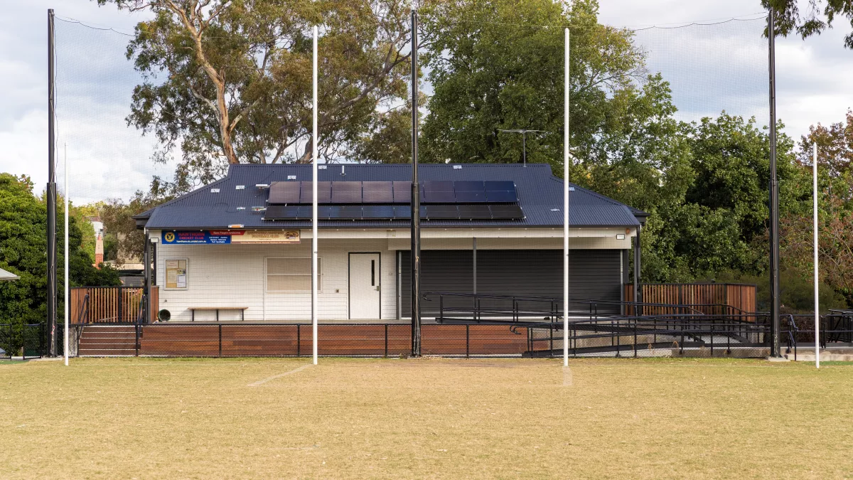 a small, white pavilion at a sportsground