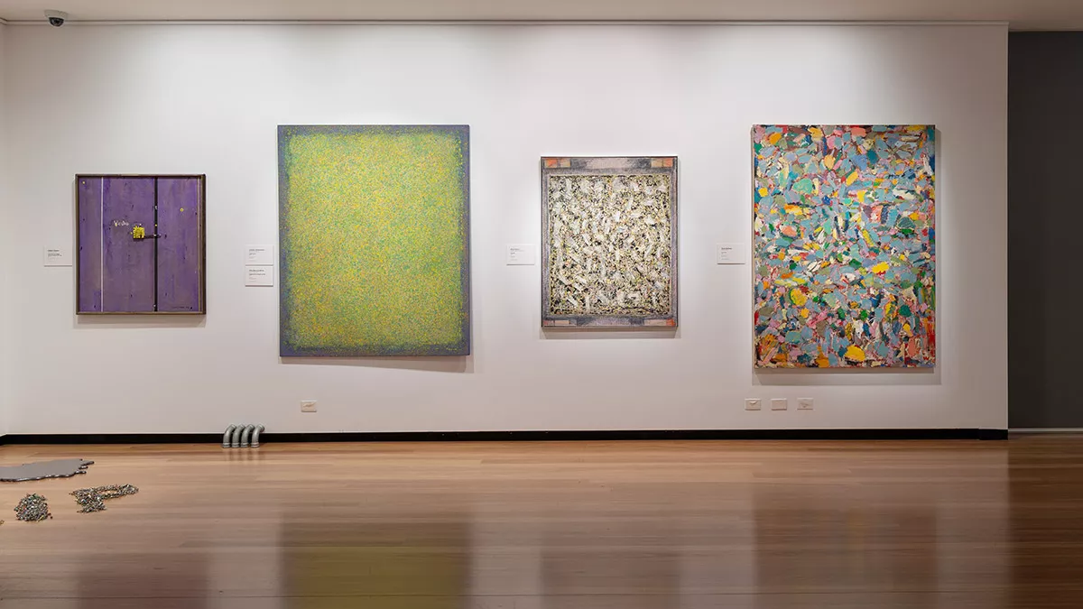 Installation view of abstract paintings hanging in a gallery