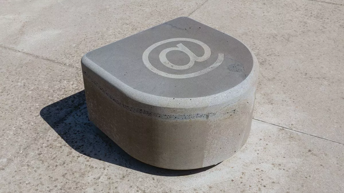 a smooth stone, curved at the front and flat on the top. There is a large at symbol carved into the top.