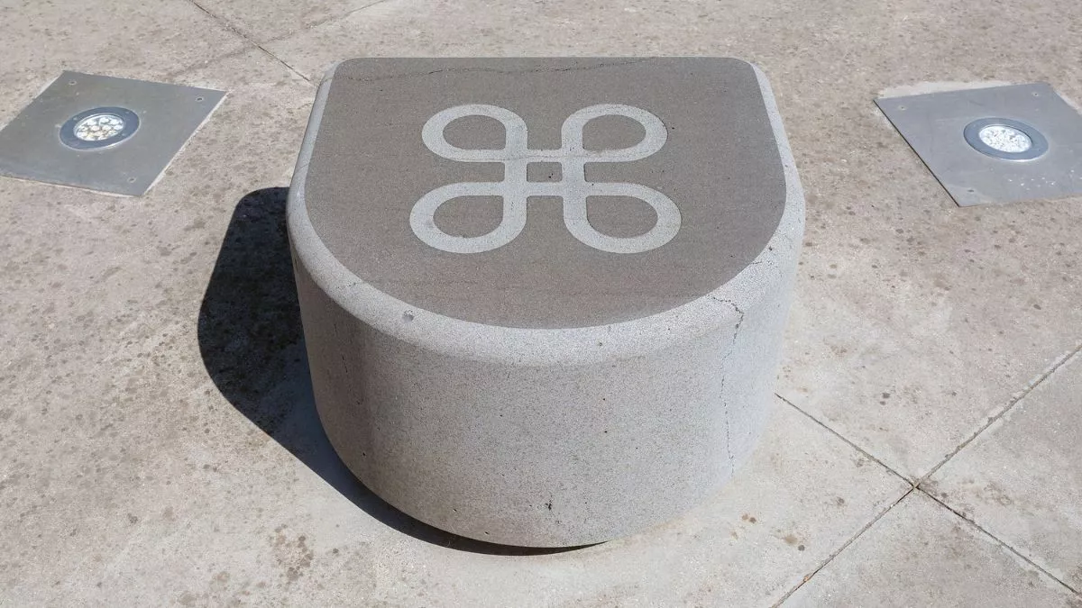 a smooth stone, curved at the front and flat on the top. There is a large infinity symbol carved into the top