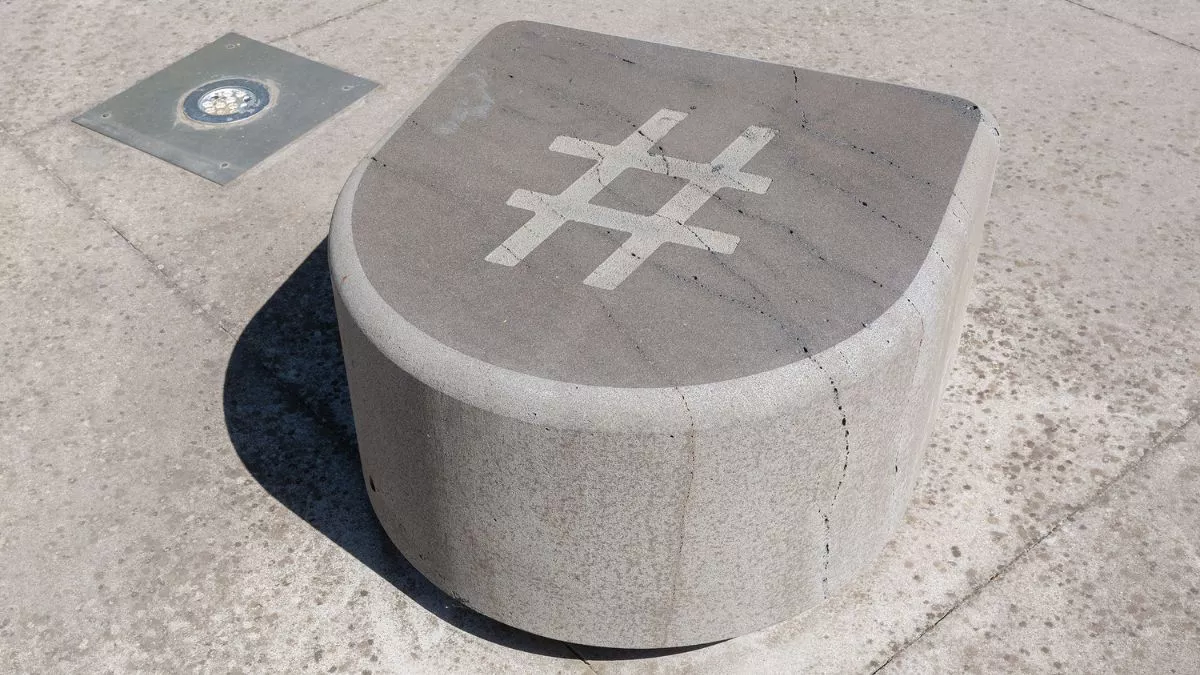 a smooth stone, curved at the front and flat on the top. There is a large hash symbol cared into the top.