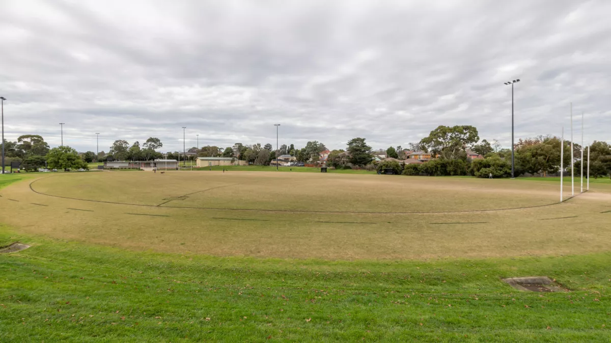 An circular sportsground. AFL goal posts are to the right