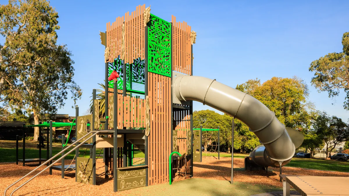 a timber climbing structure with a tubular slide in a playground