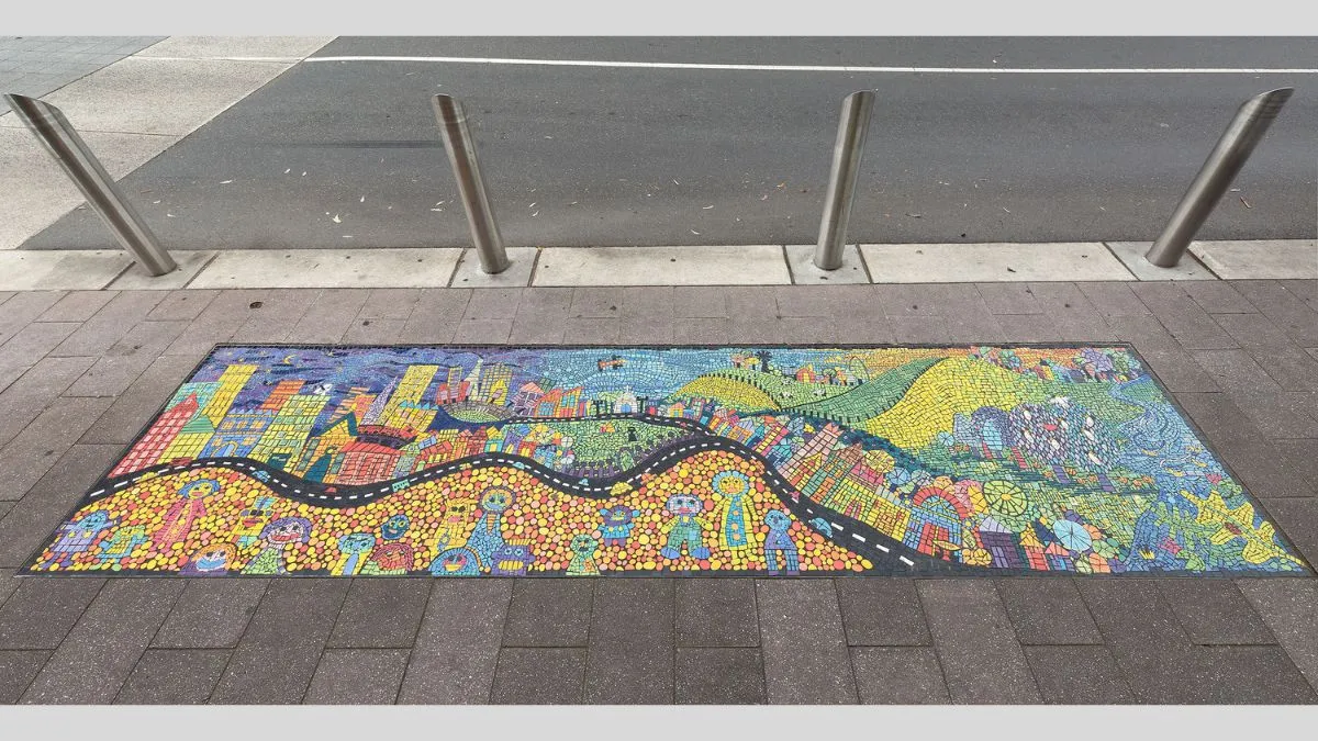 A colourful mosaic featuring smiling people, buildings and green hills