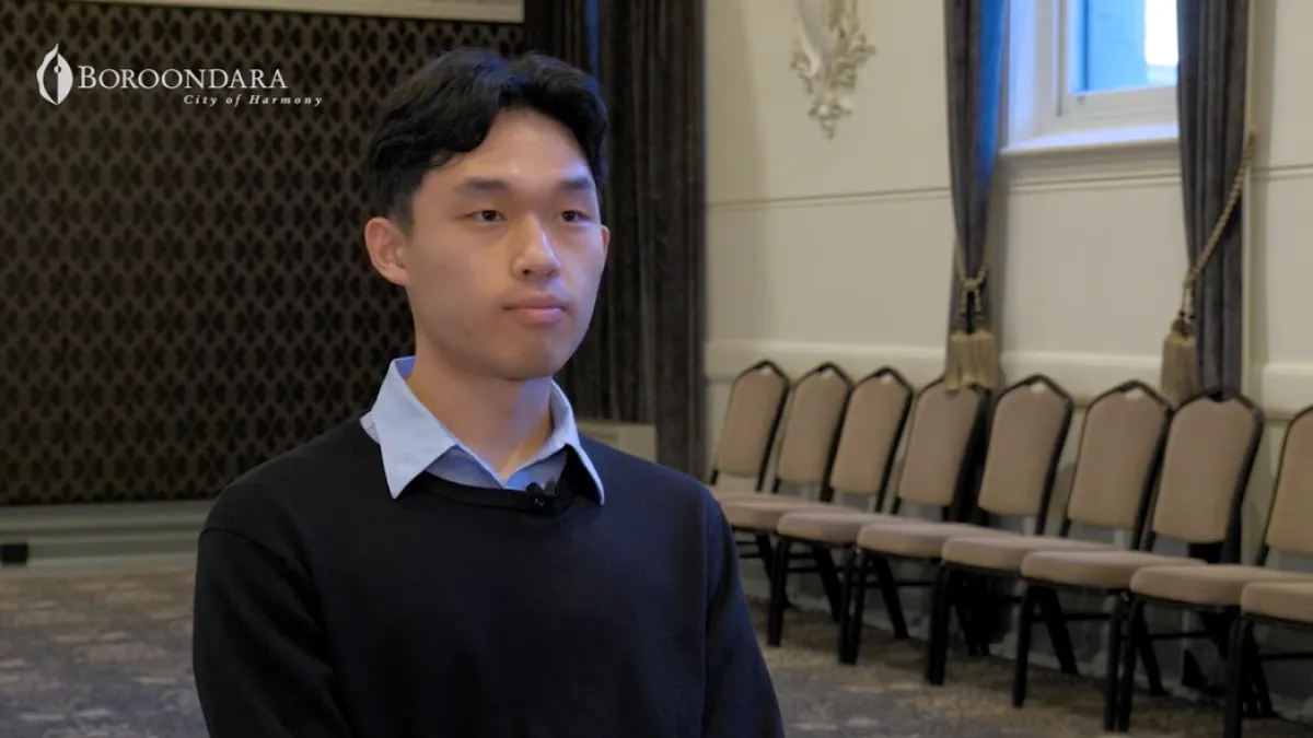 A man sits in a hall for an interview.