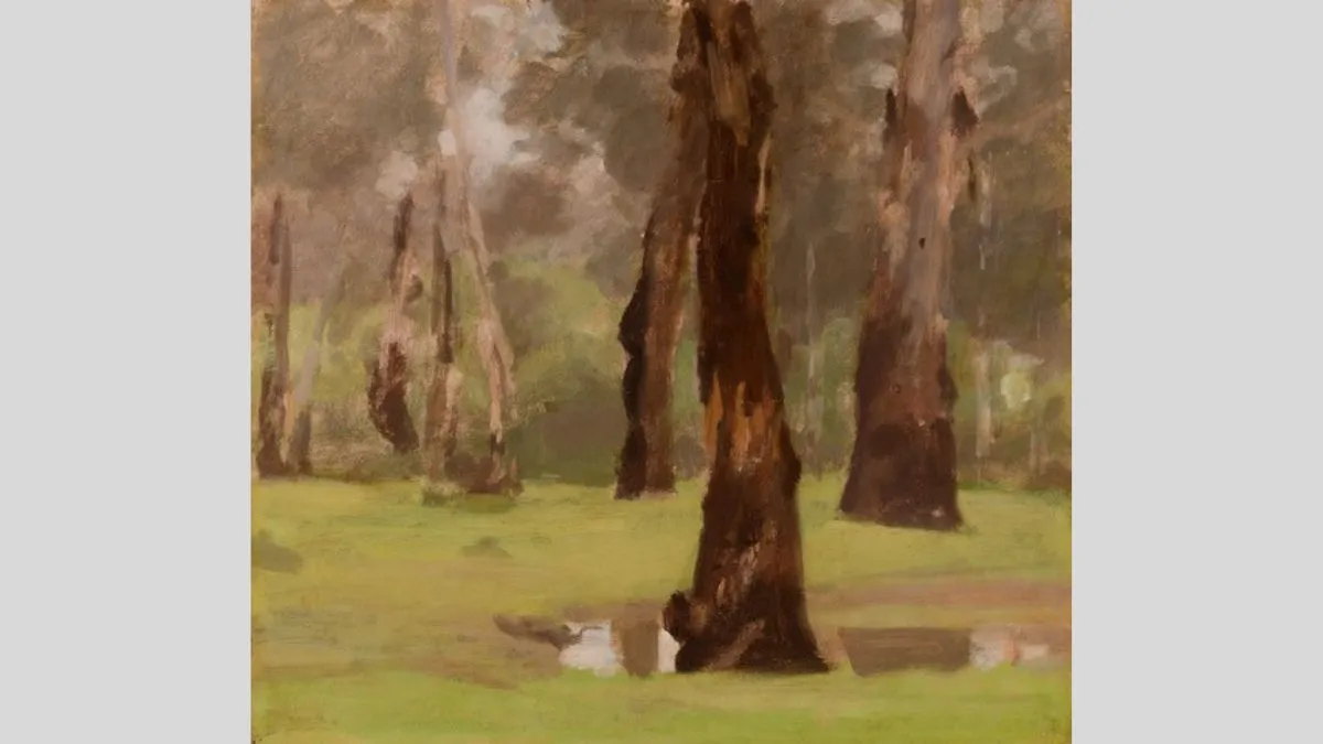 A tightly cropped composition of green grass and brown tree trucks, with one tree in the foreground within a puddle of water, and five other trees in a line behind. 