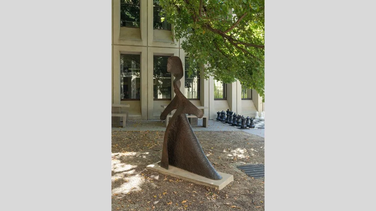 A life-size bronze figure of a woman in a long robe