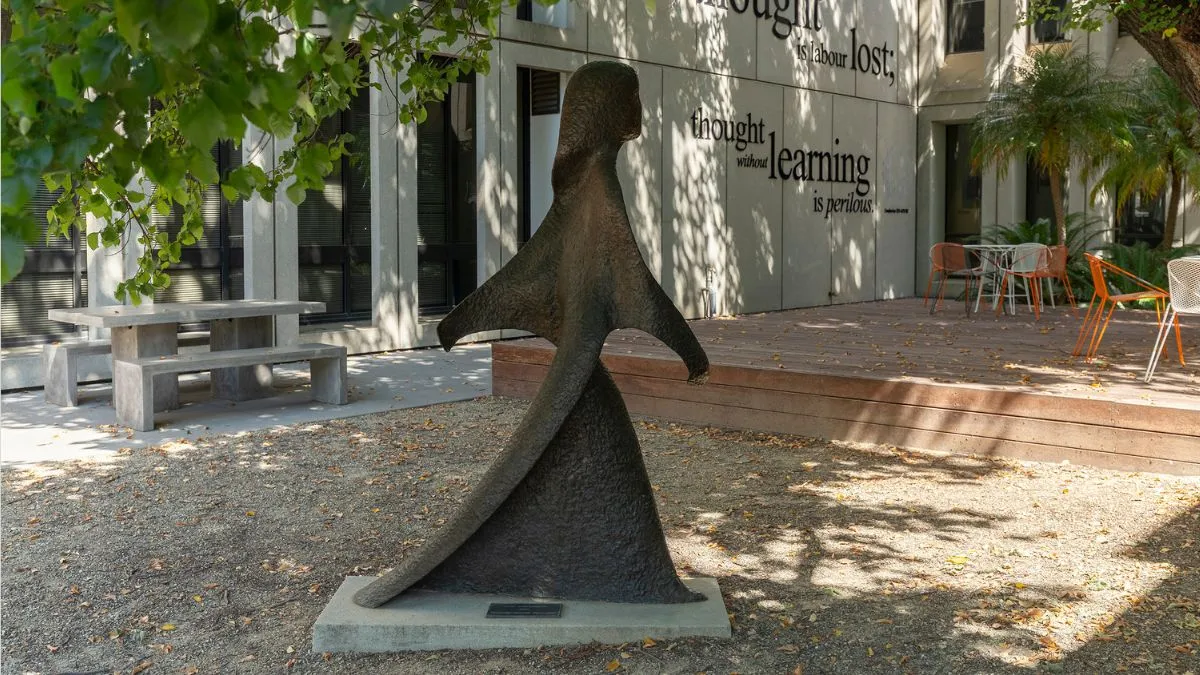 A life-size bronze figure of a woman in a long robe