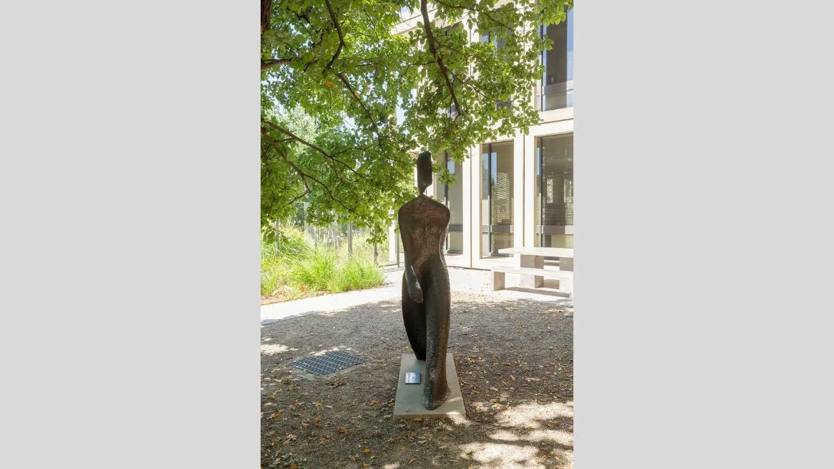 A life-size bronze figure of a woman in a long robe