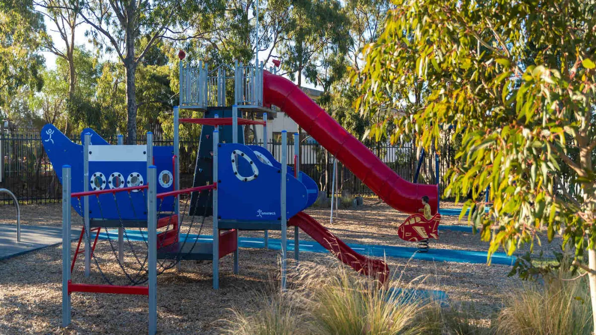 A colourful playground including 2 slides,, a climbing bridge.