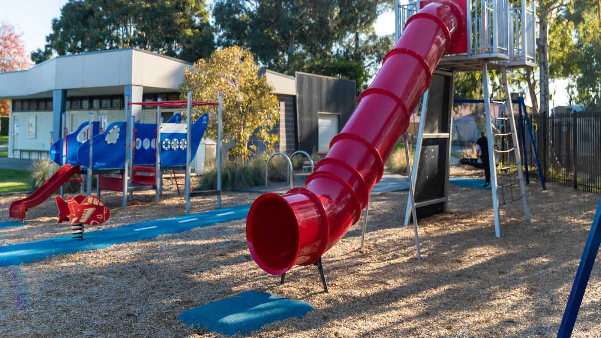 A playground including 2 slides and a spring rocker.