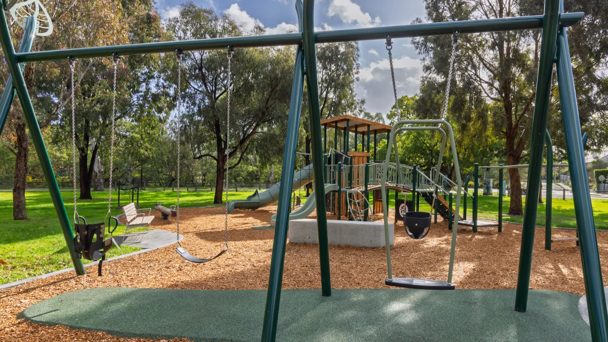 A series of swings at different heights in a playground