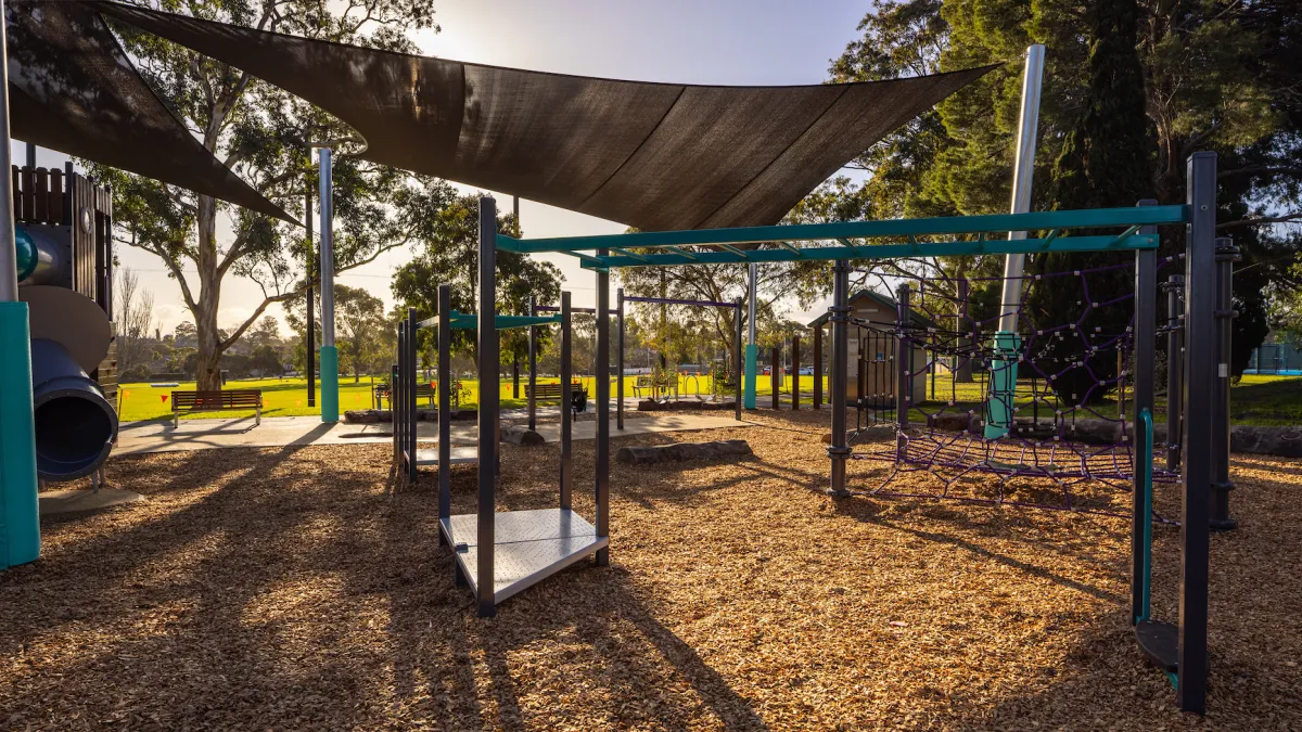 Panoramic perspective of a small playground in late afternoon sunlight