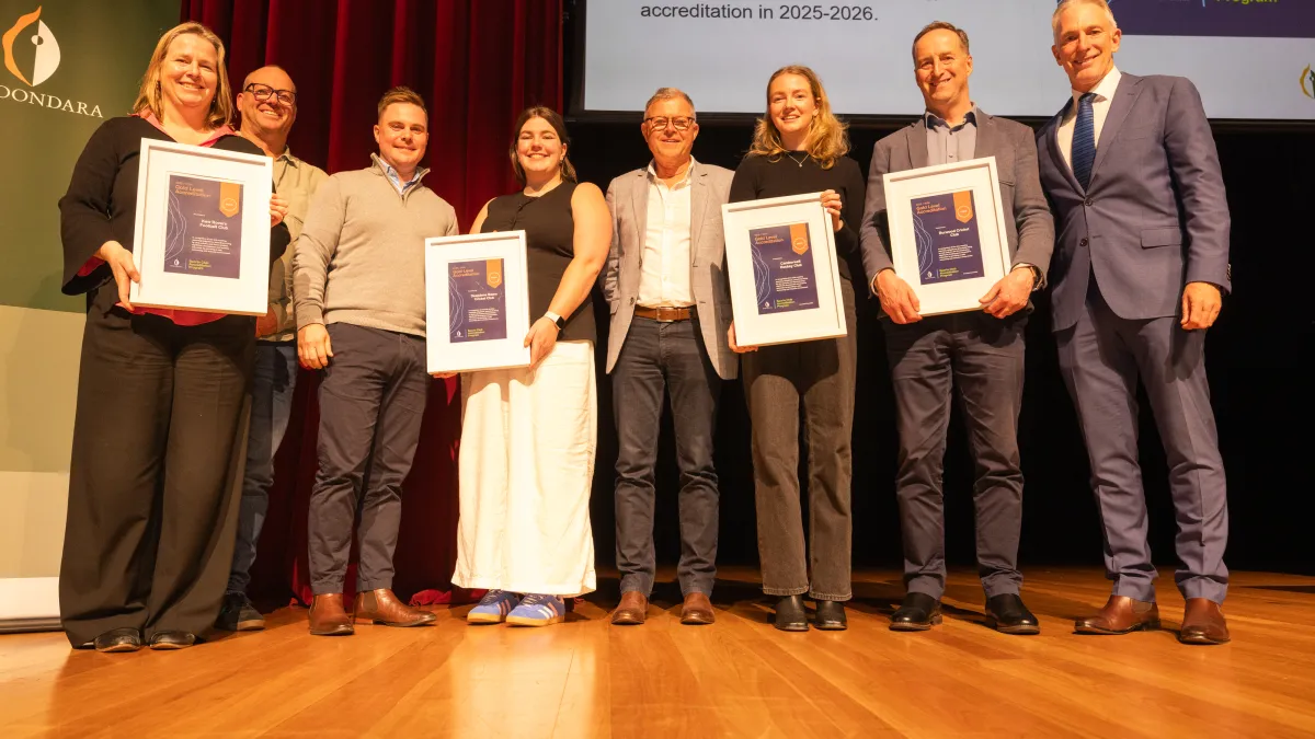 Representatives from 4 gold-accredited sports clubs accept awards on stage