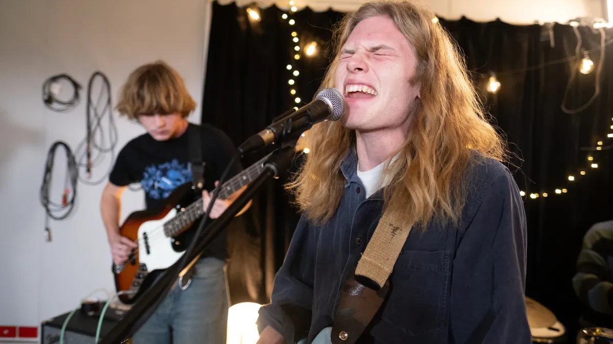 2 long haired guys rock out in performance