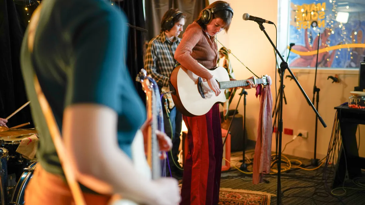 A 3 piece band performs on a small stage
