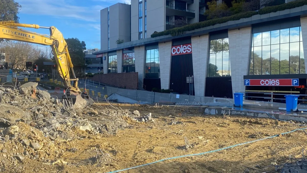 A digger moving demolished debris at a building site