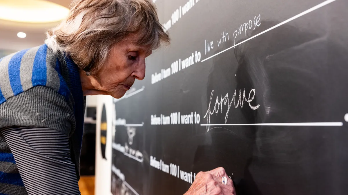 A woman writes on a blackboard
