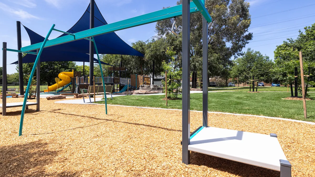 Monkey bars on tan bark ground cover in a playground