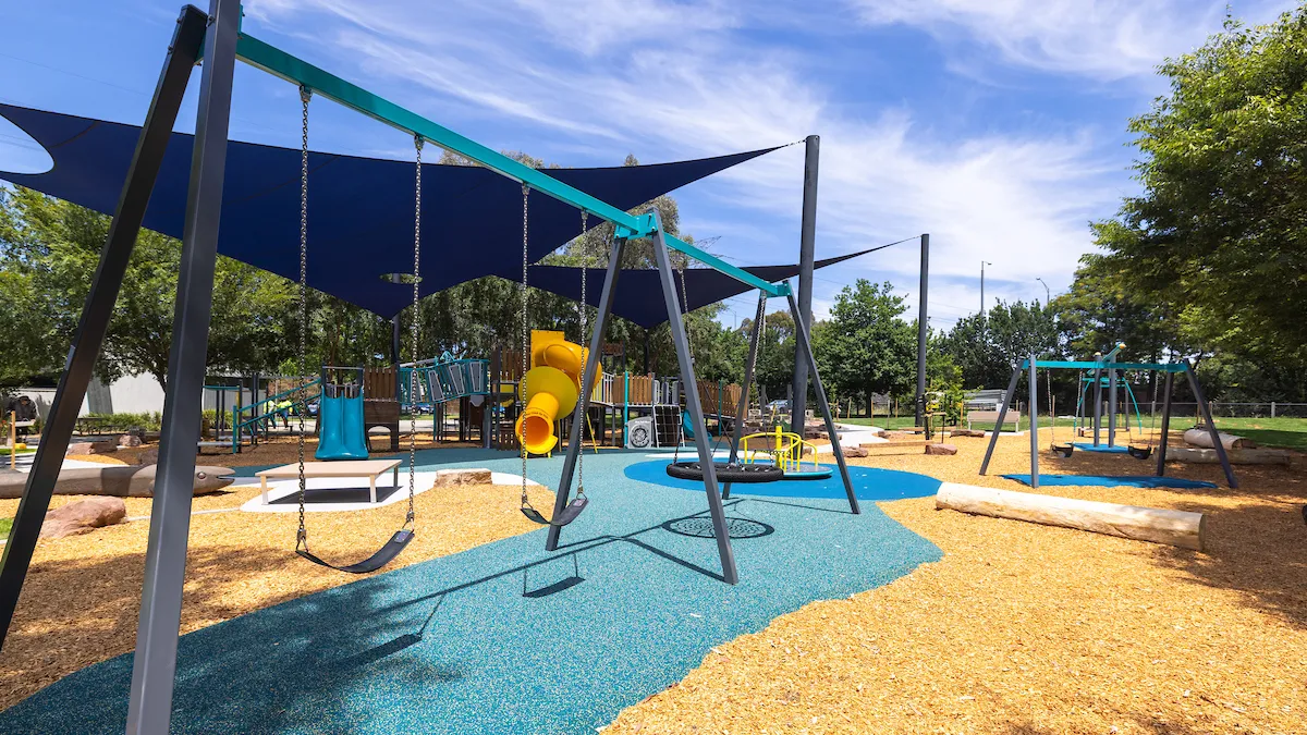 A frame with 3 swings on it in a playground