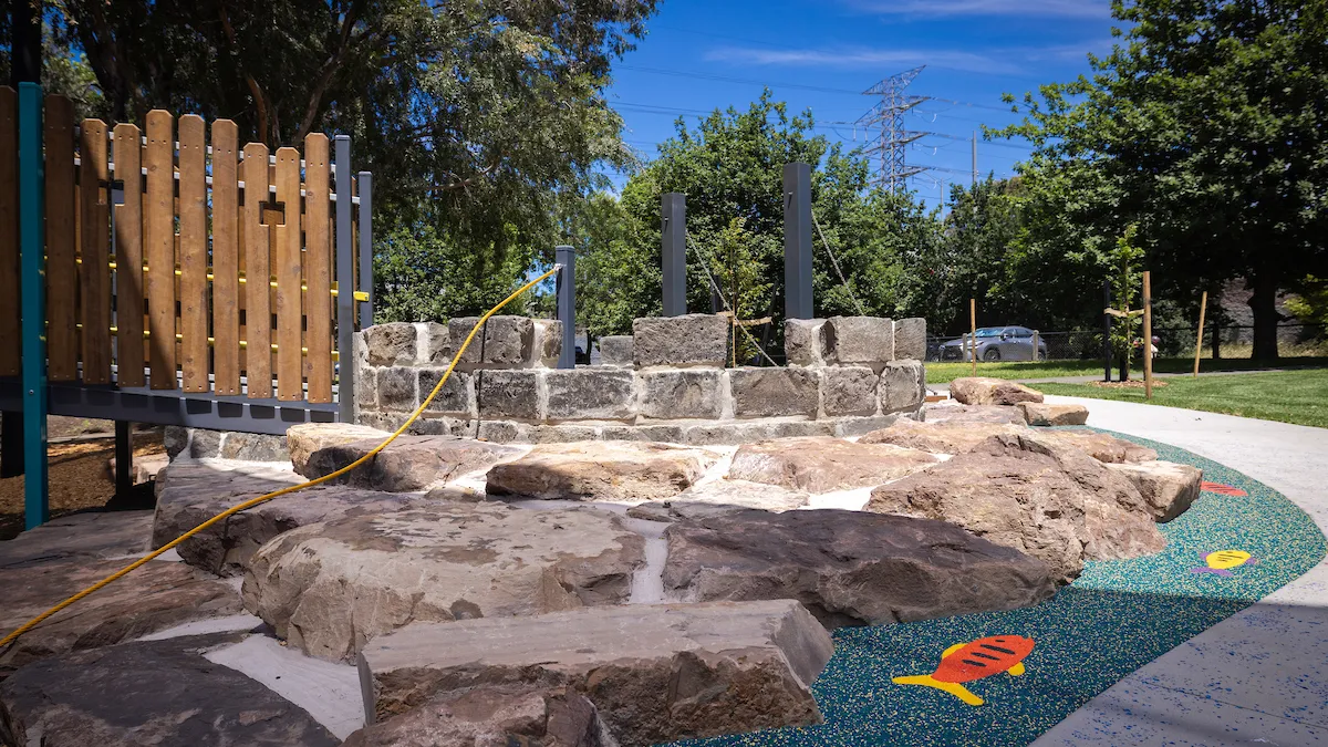 a rock-lined, water-play feature in a child's playground