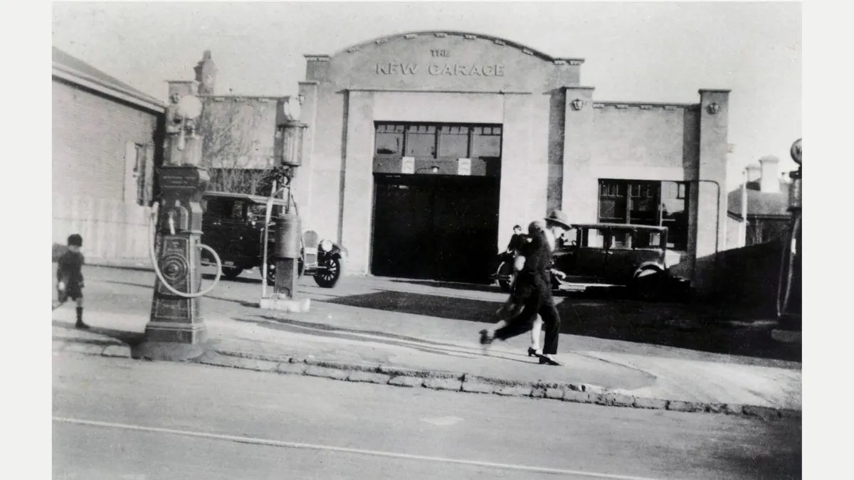 The outside of a cement car garage with a sign saying Kew Garage