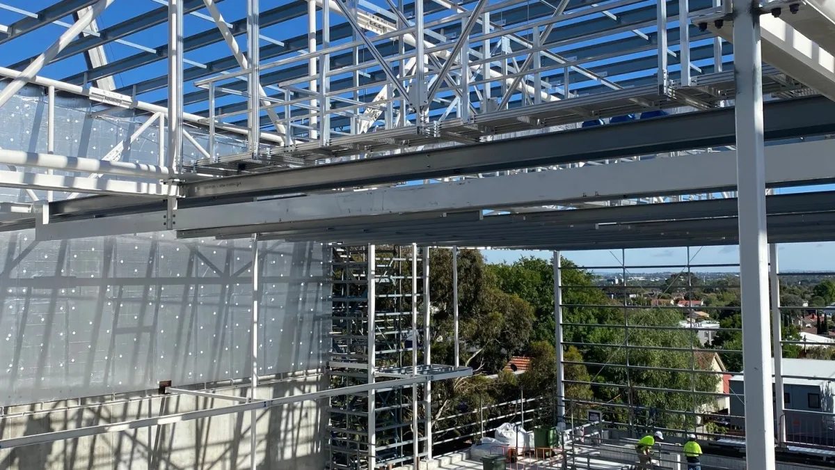 A building with exposed steel frames and a pool area