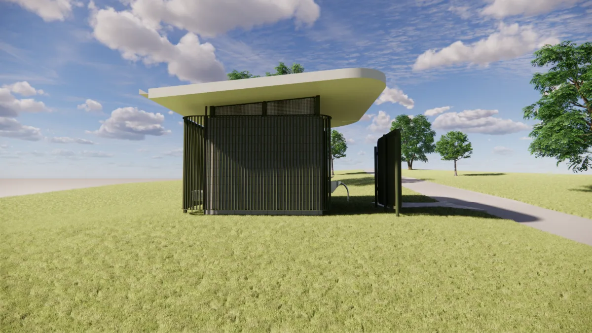 Side view from the east of a toilet block. It is next to a footpath and surrounded by trees. the toilet is green and cream to help it blend into the surroundings.