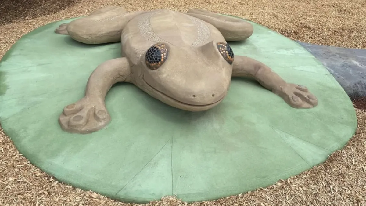 A climbable sculpture of a frog at a playground, for sensory play