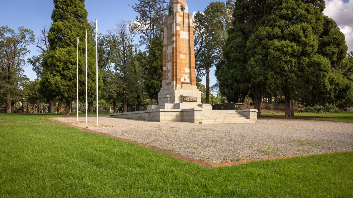 Side view of the restored St James Park war memorial with 3 flag poles.