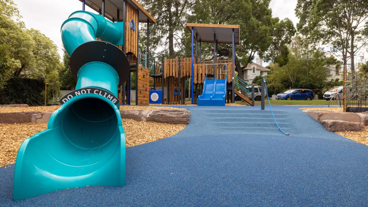 A turquoise-coloured, enclosed slide at a playground