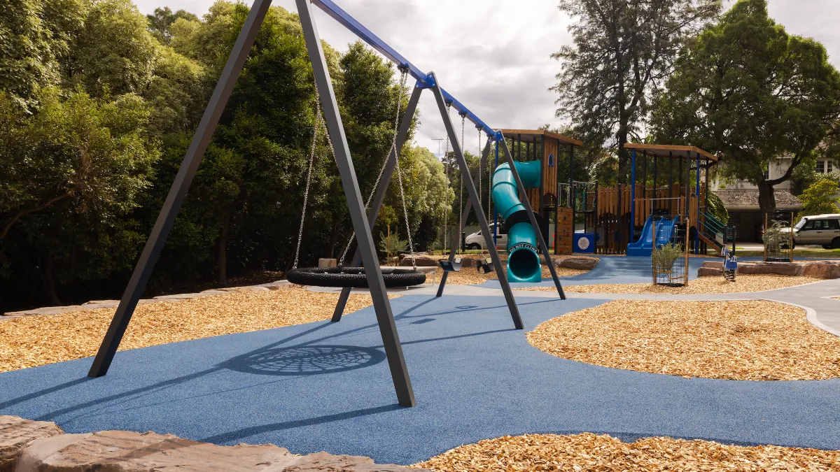 A swing set including a basket swing at a playground
