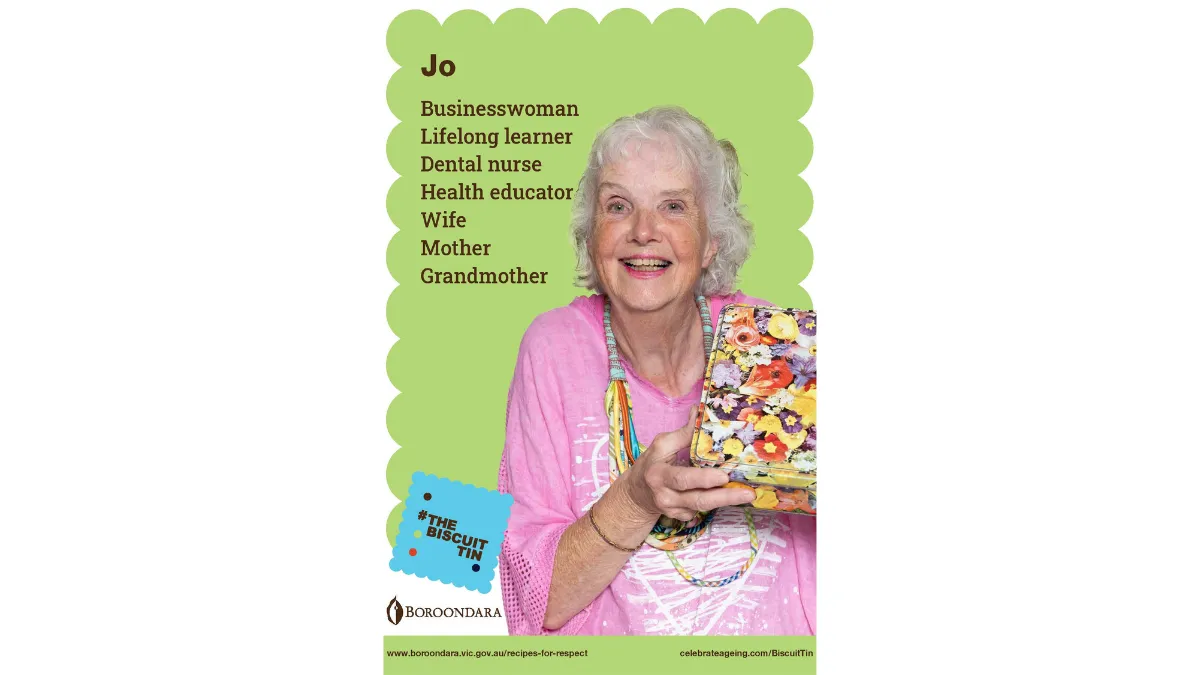 Jo wears a pink top with a loopy string necklace. Her biscuit tin is covered in flowers of all varieties.