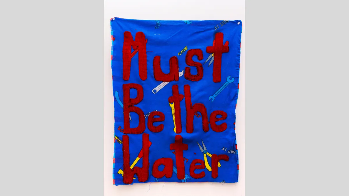 Fabric banner that says 'Must be the water'
