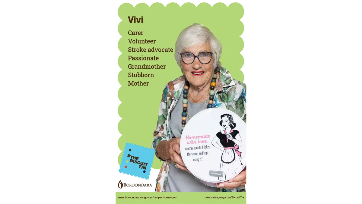 Vivi is wearing round glasses and a and a chunky beaded necklace.She's holding a large round biscuit tin that says 'Homemade with love".