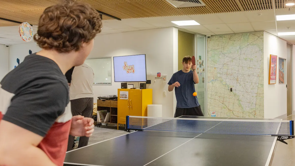 Two young people playing table tennis at the youth hub.