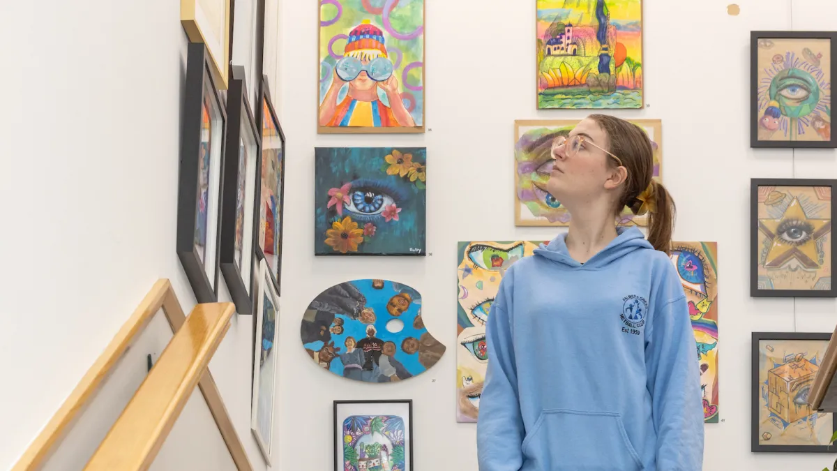Young person standing on the stairs up to the youth hub looking at artwork on the walls.